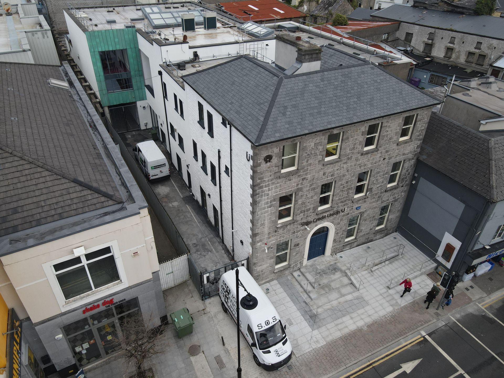 An aerial view of a building with a van parked in front of it