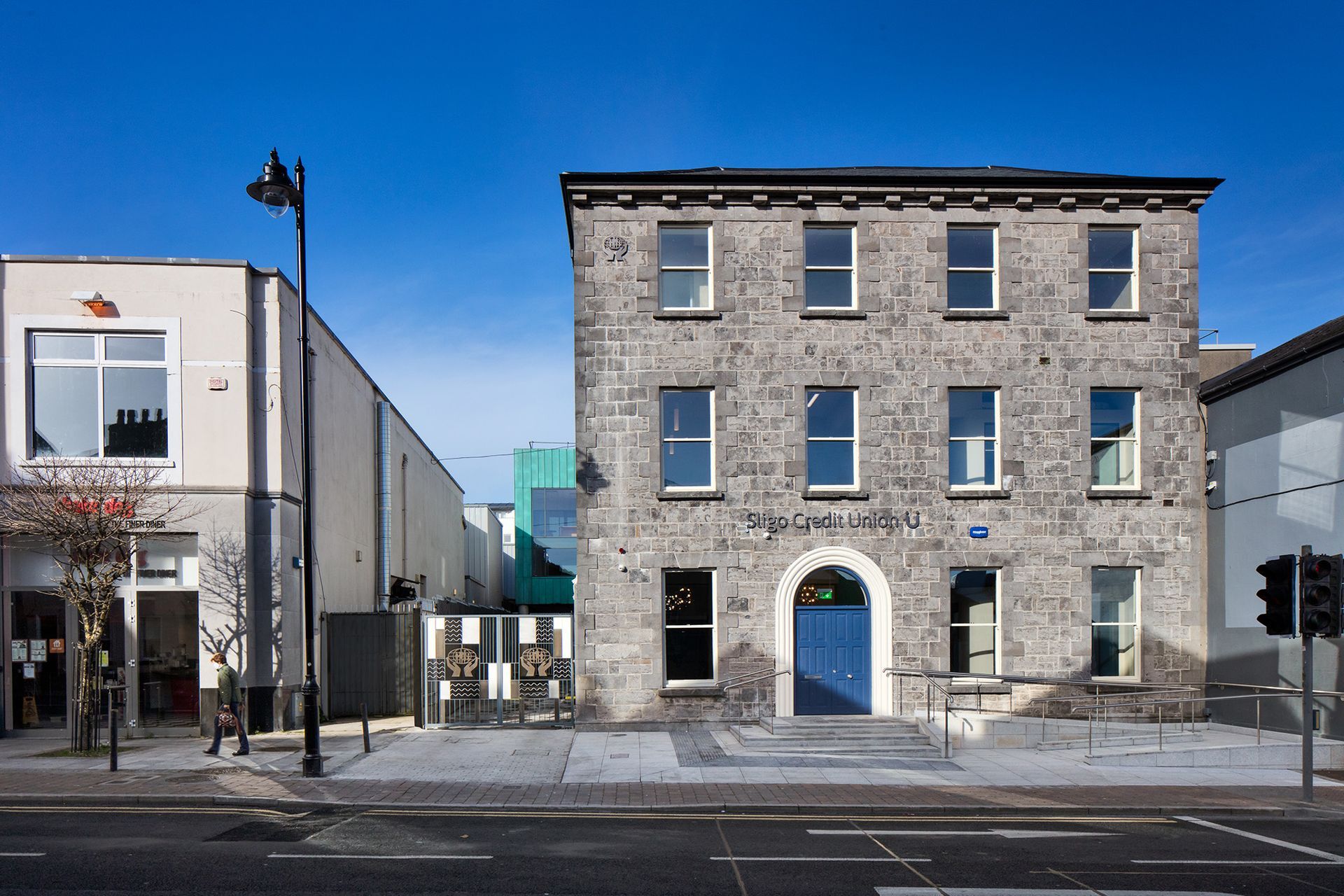 A large stone building with a blue door and stairs