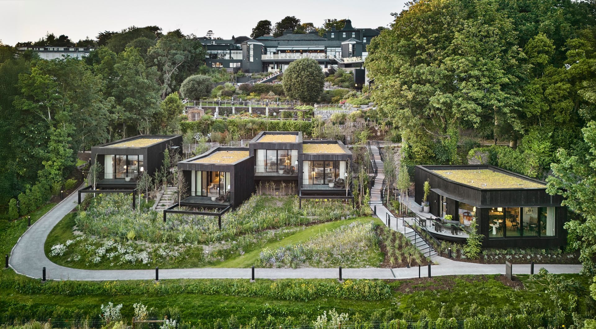 A large building with a lot of windows is sitting on the corner of a street.