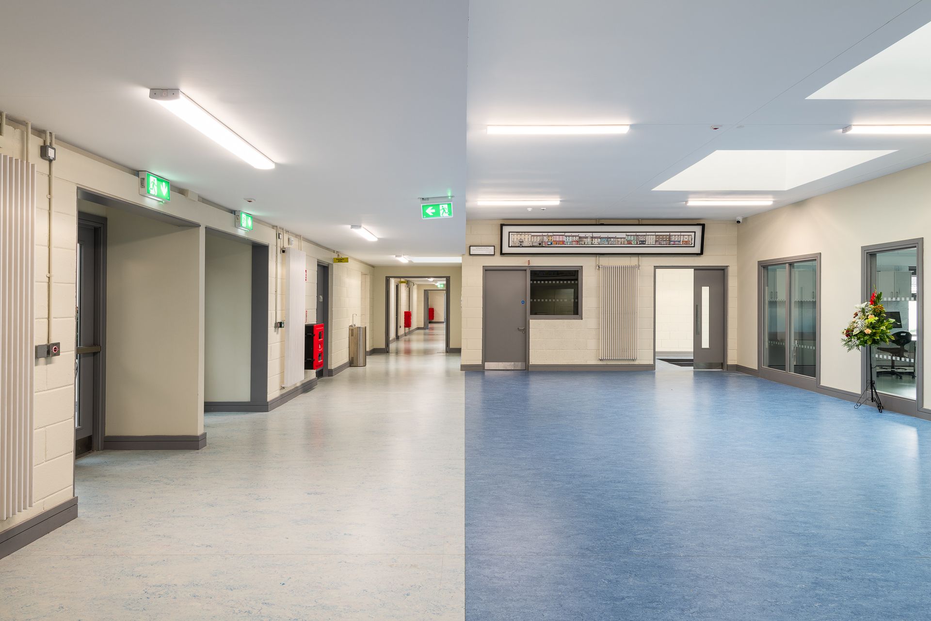 A hallway with a blue floor and a white wall.