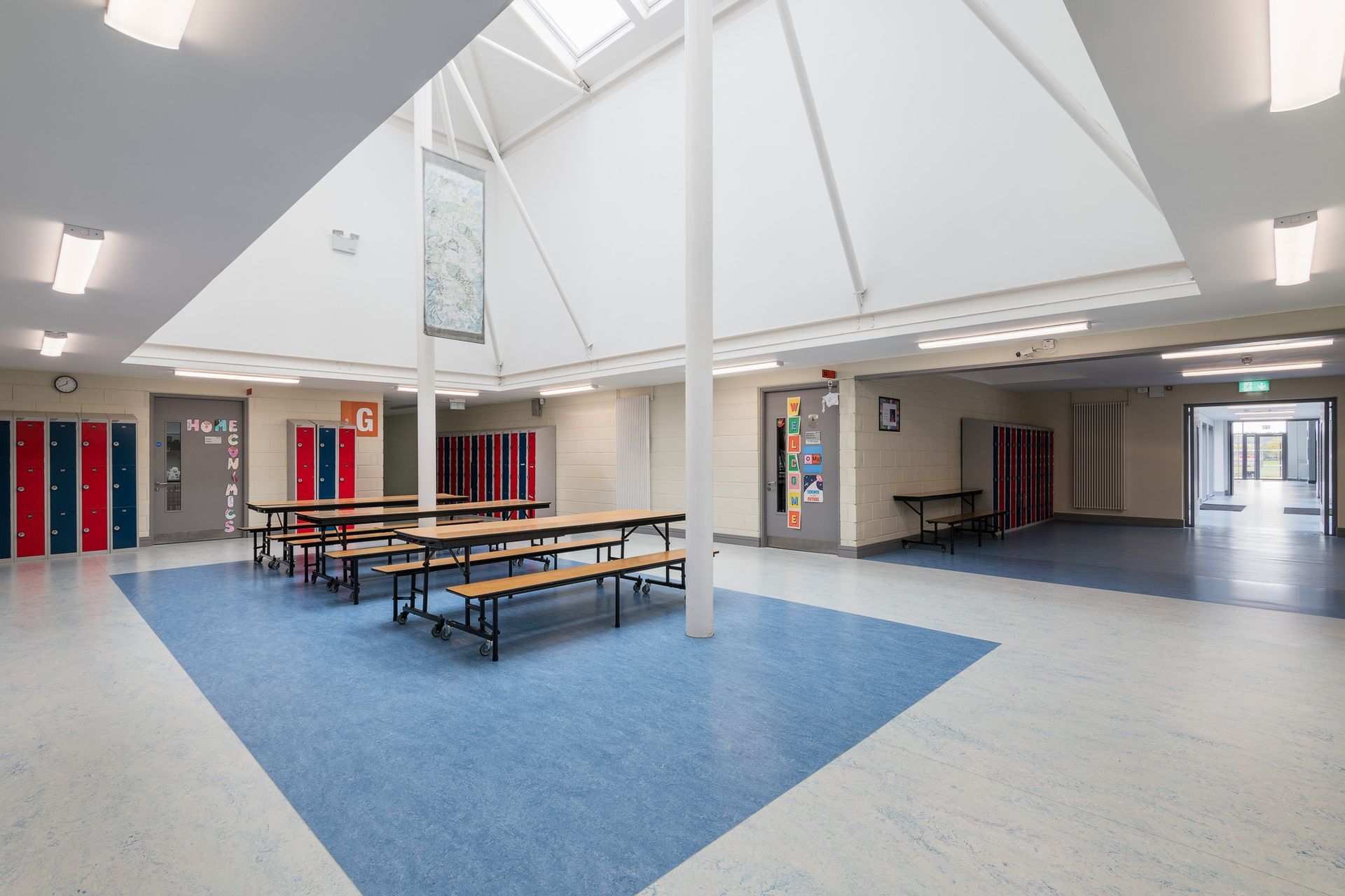 A large hallway with tables and benches in it.