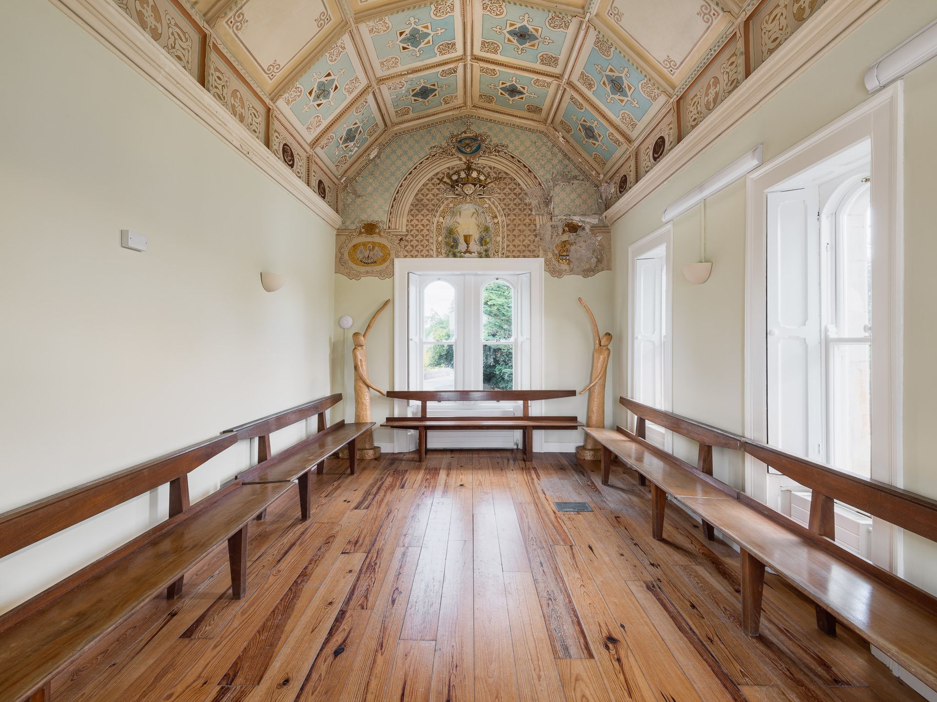 A long narrow room with wooden benches and a ceiling.