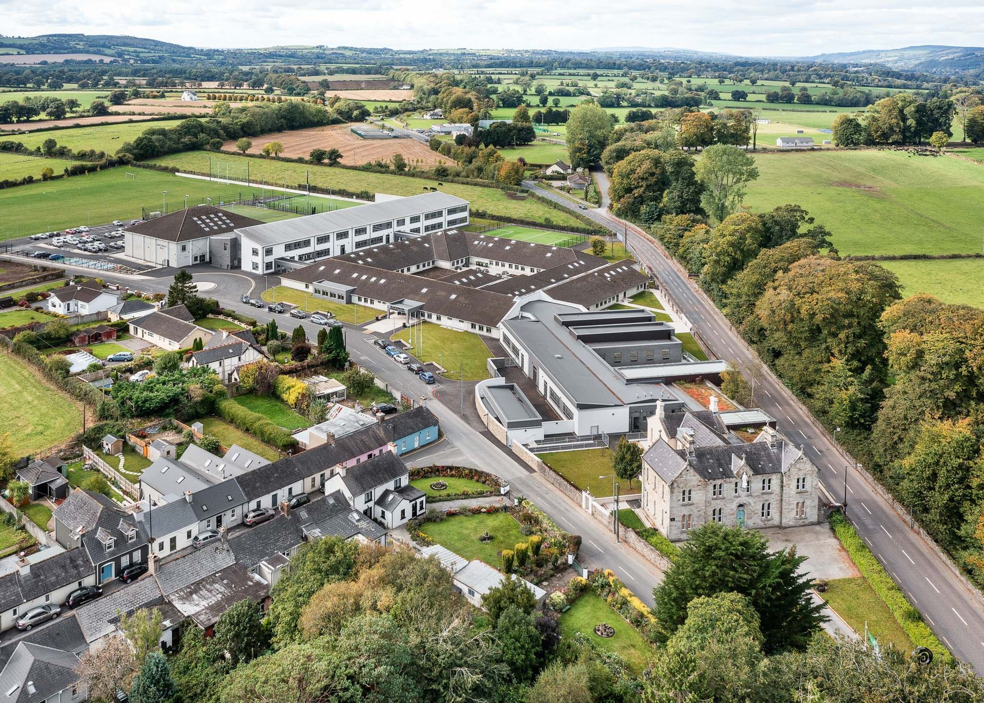 An aerial view of a small town surrounded by fields and trees.