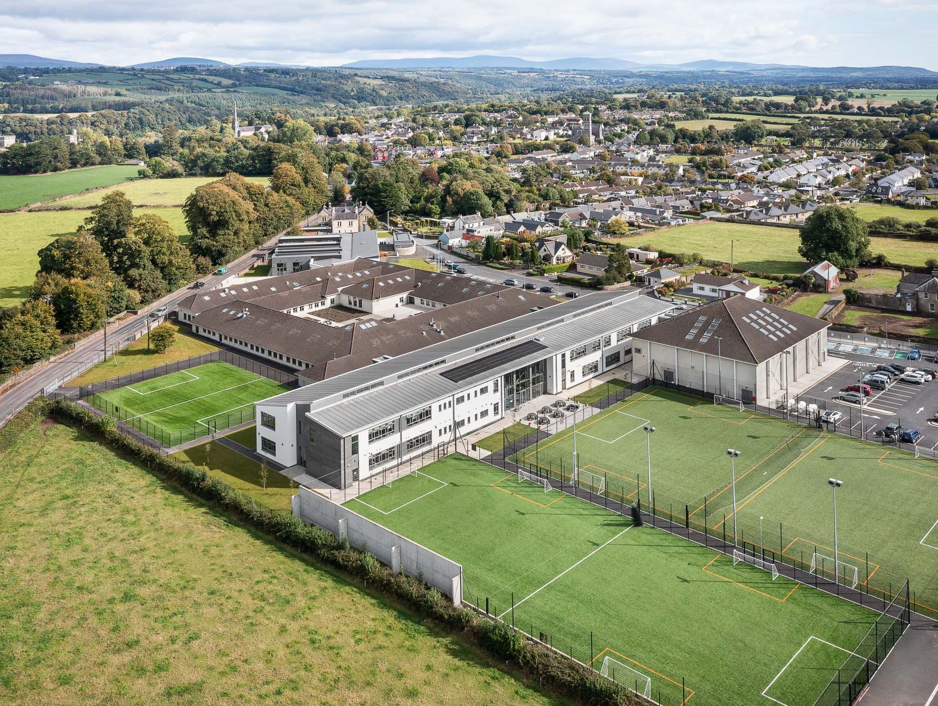 An aerial view of a large building with soccer fields in front of it.