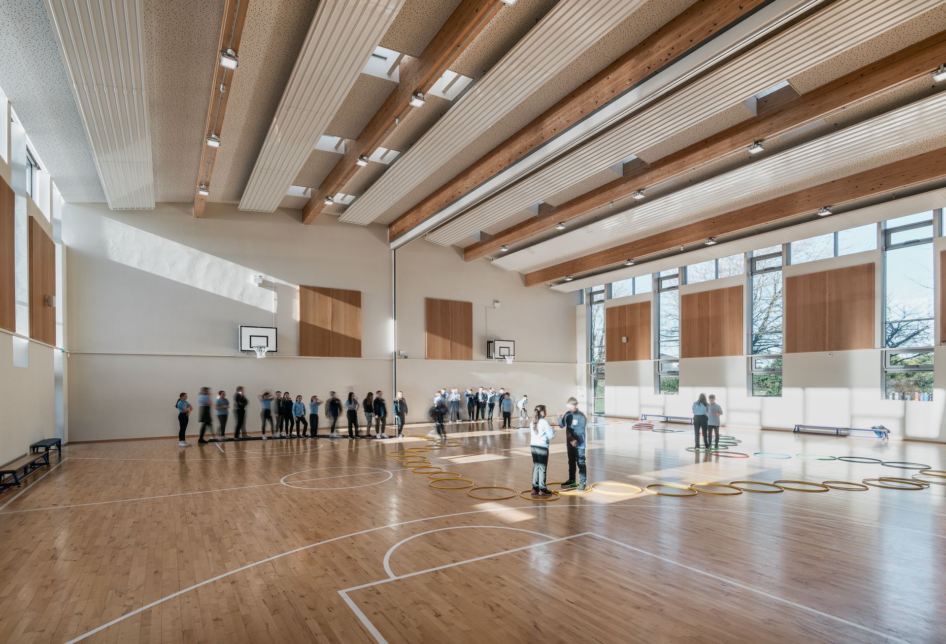 A group of people are standing in a large gym.