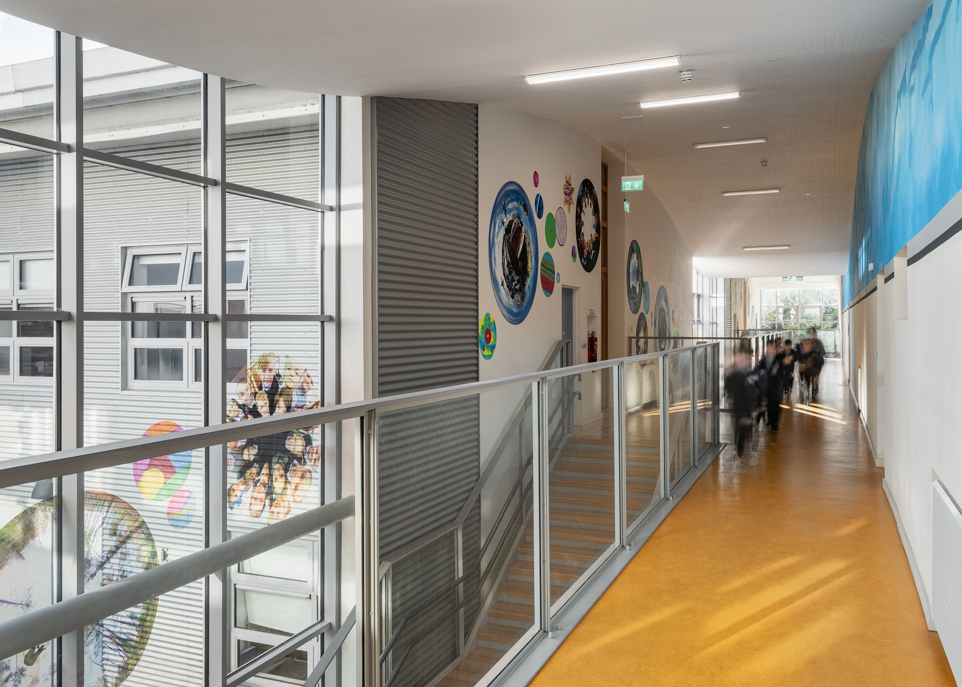 A group of people are walking down a long hallway in a building.