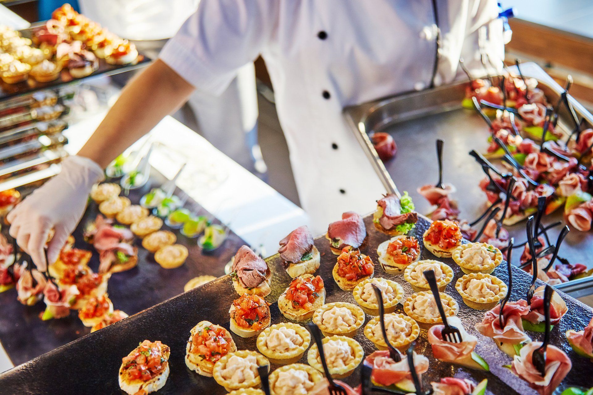 A chef is preparing a variety of appetizers on a table.