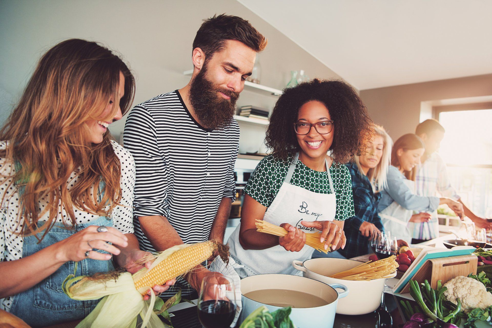 A group of people are cooking together in a kitchen.