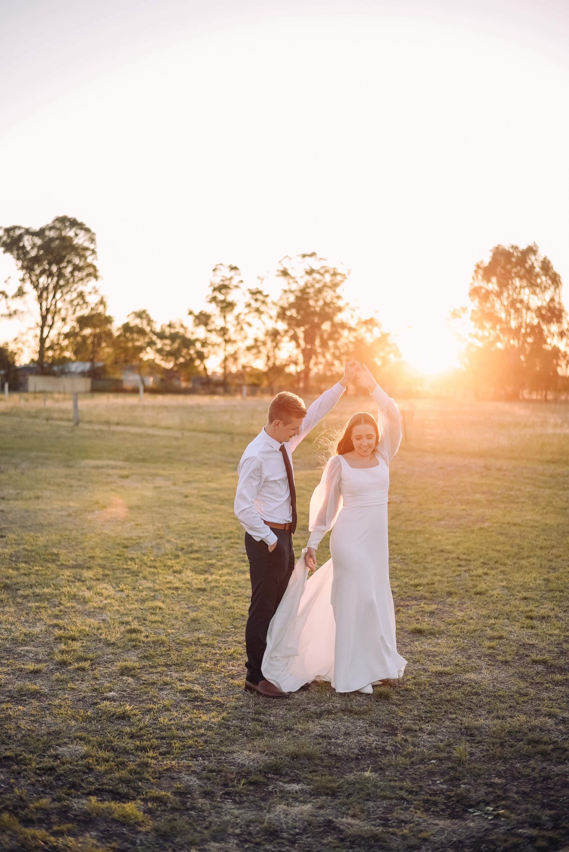 A Bride and Groom are Dancing in a Field at Sunset - Function Venue in Hillvue, NSW