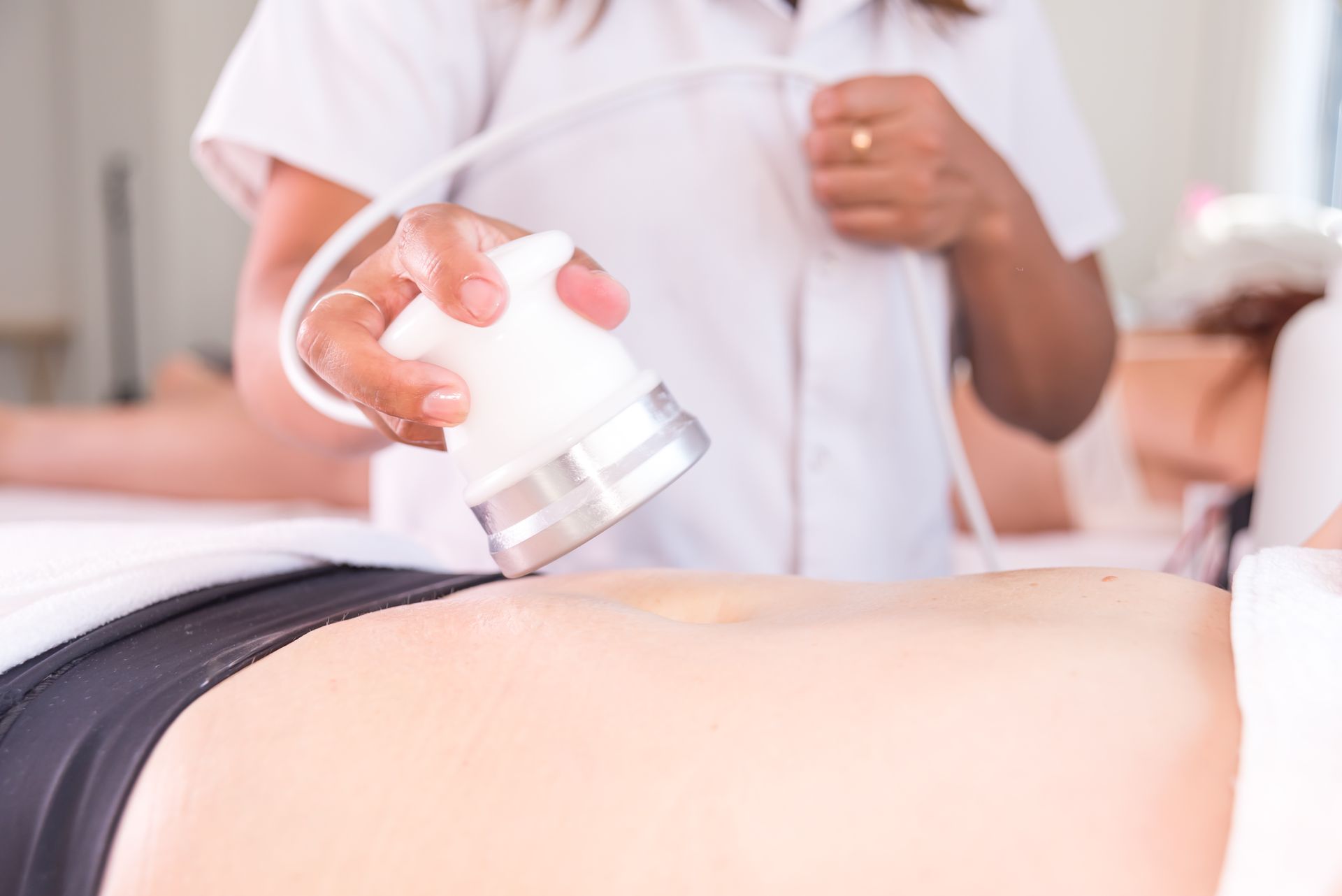A woman is getting an ultrasound on her back in a spa.