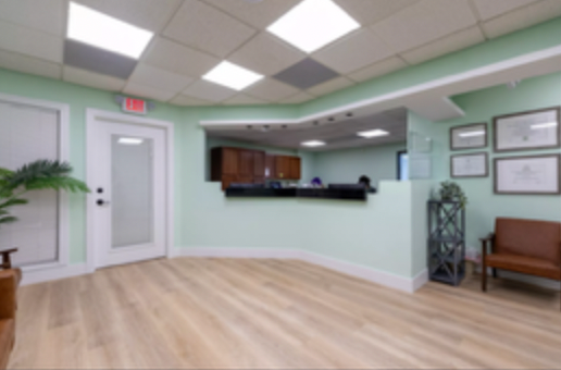 A waiting room with a reception desk and chairs
