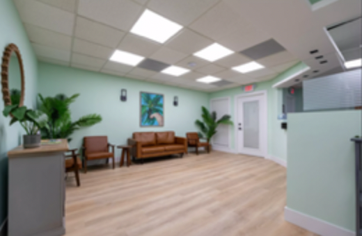 A waiting room with a couch and chairs in it