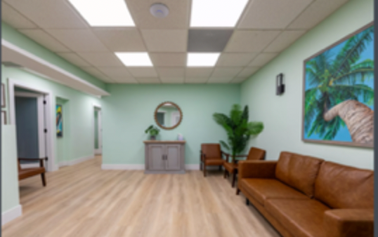 A waiting room with a brown couch and chairs
