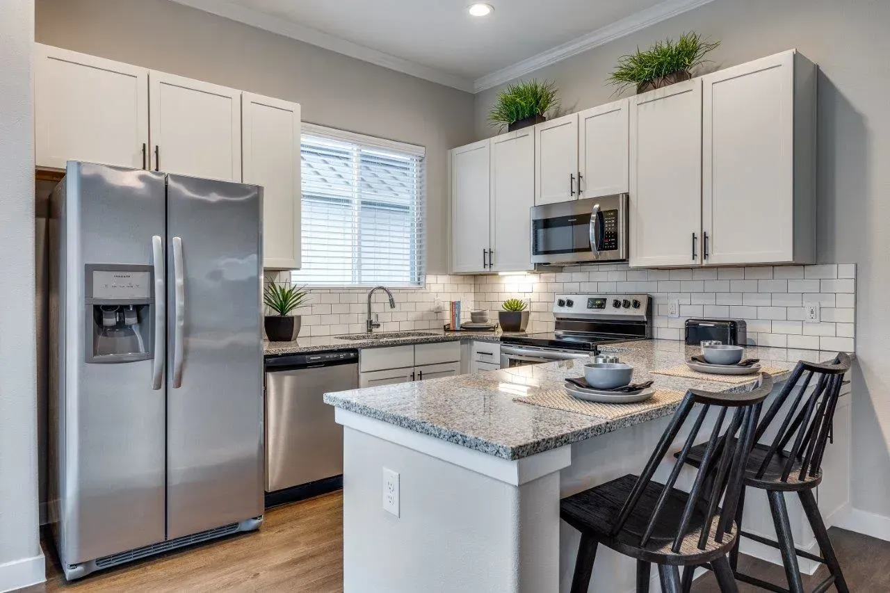 A kitchen with stainless steel appliances and granite countertops.