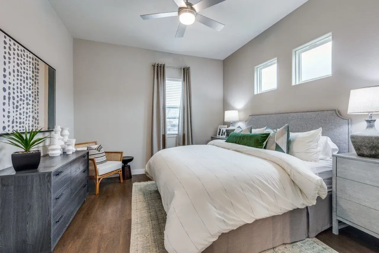 A bedroom with a king-size bed and a ceiling fan.