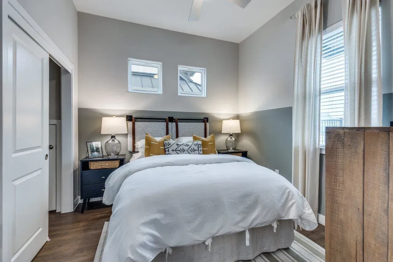A bedroom with a large bed and a ceiling fan.