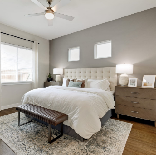 A bedroom with a king-size bed and a ceiling fan.