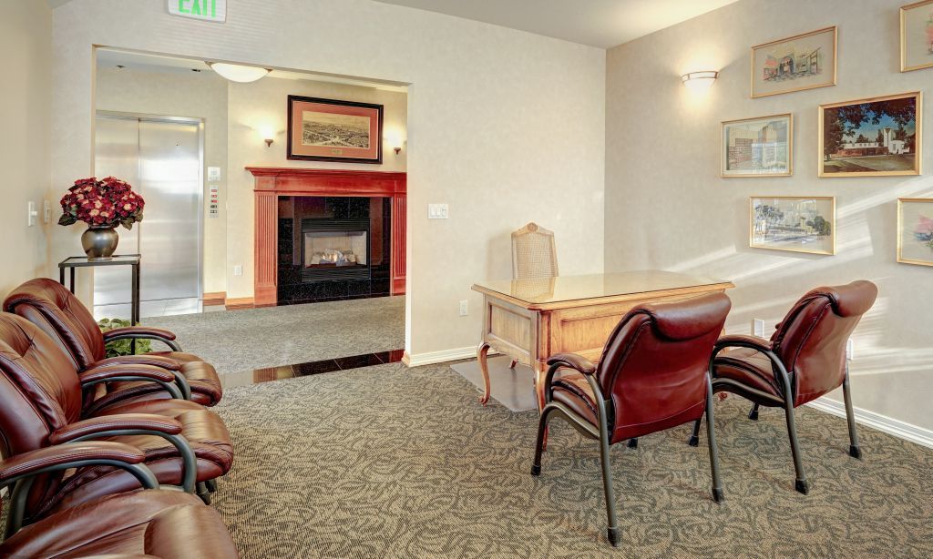 A waiting room with chairs and a fireplace.