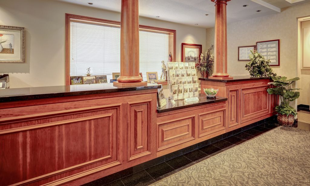 funeral home lobby with a long wooden counter and columns.