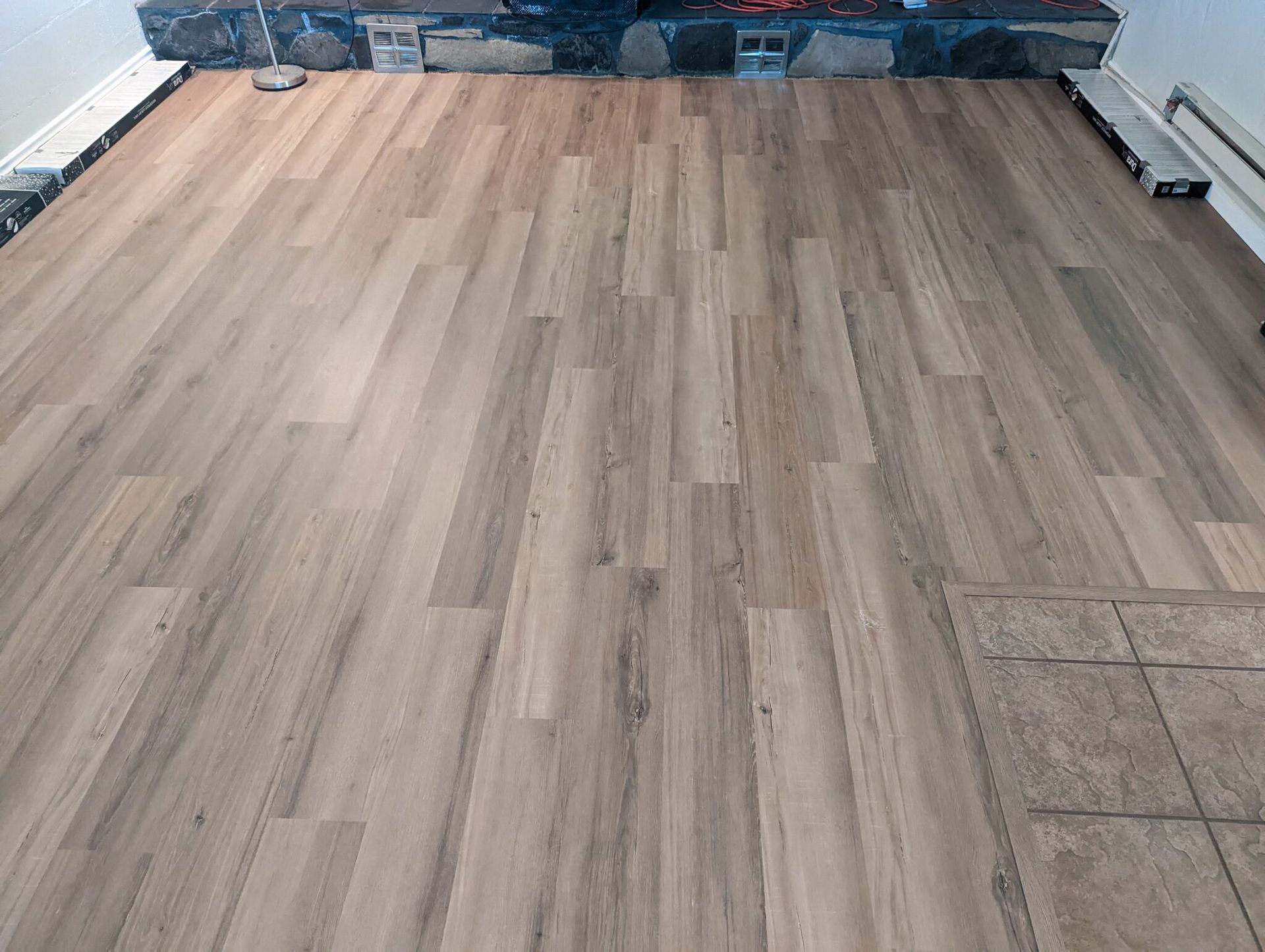 Empty room with light wood-look flooring and unfinished walls near the far end