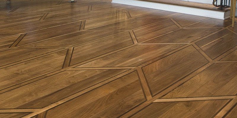 Geometric wood parquet floor with angled brown and beige planks in a room