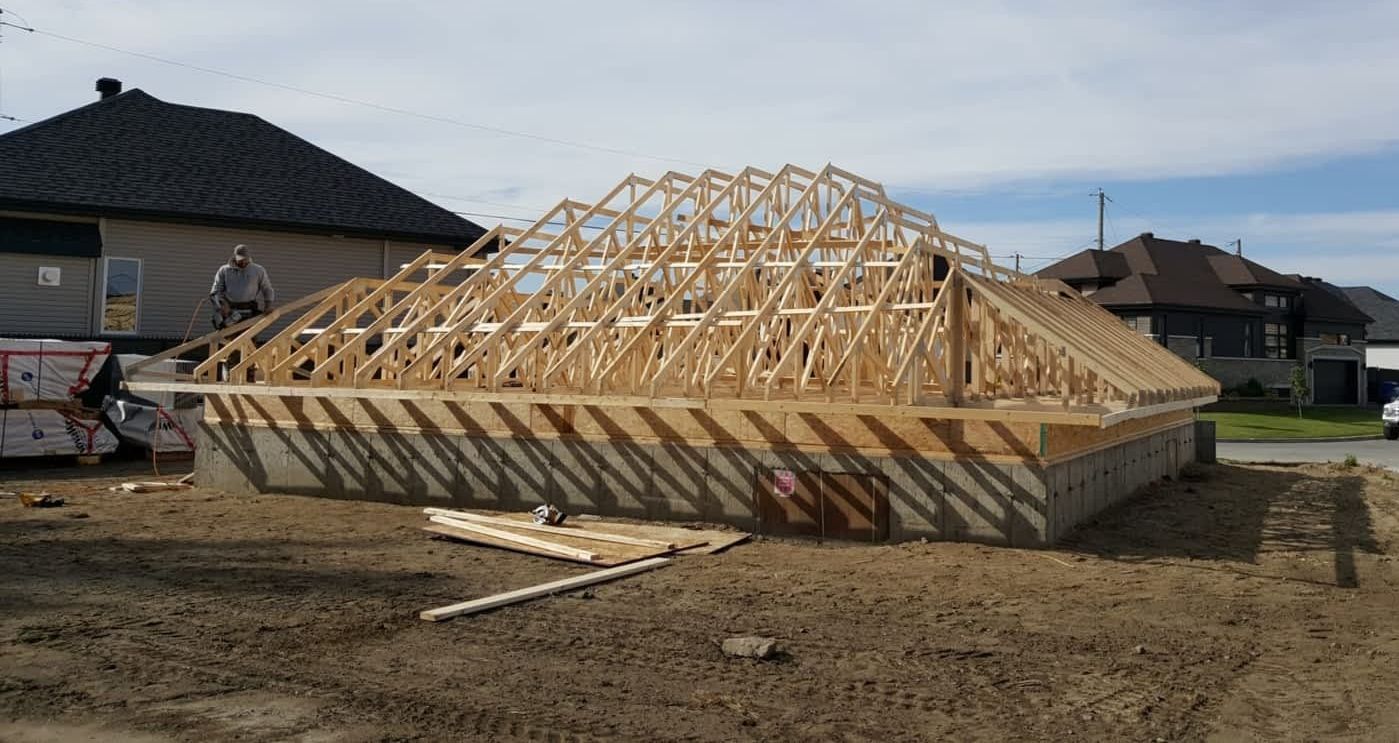 A wooden structure is being built in a yard in front of a house.