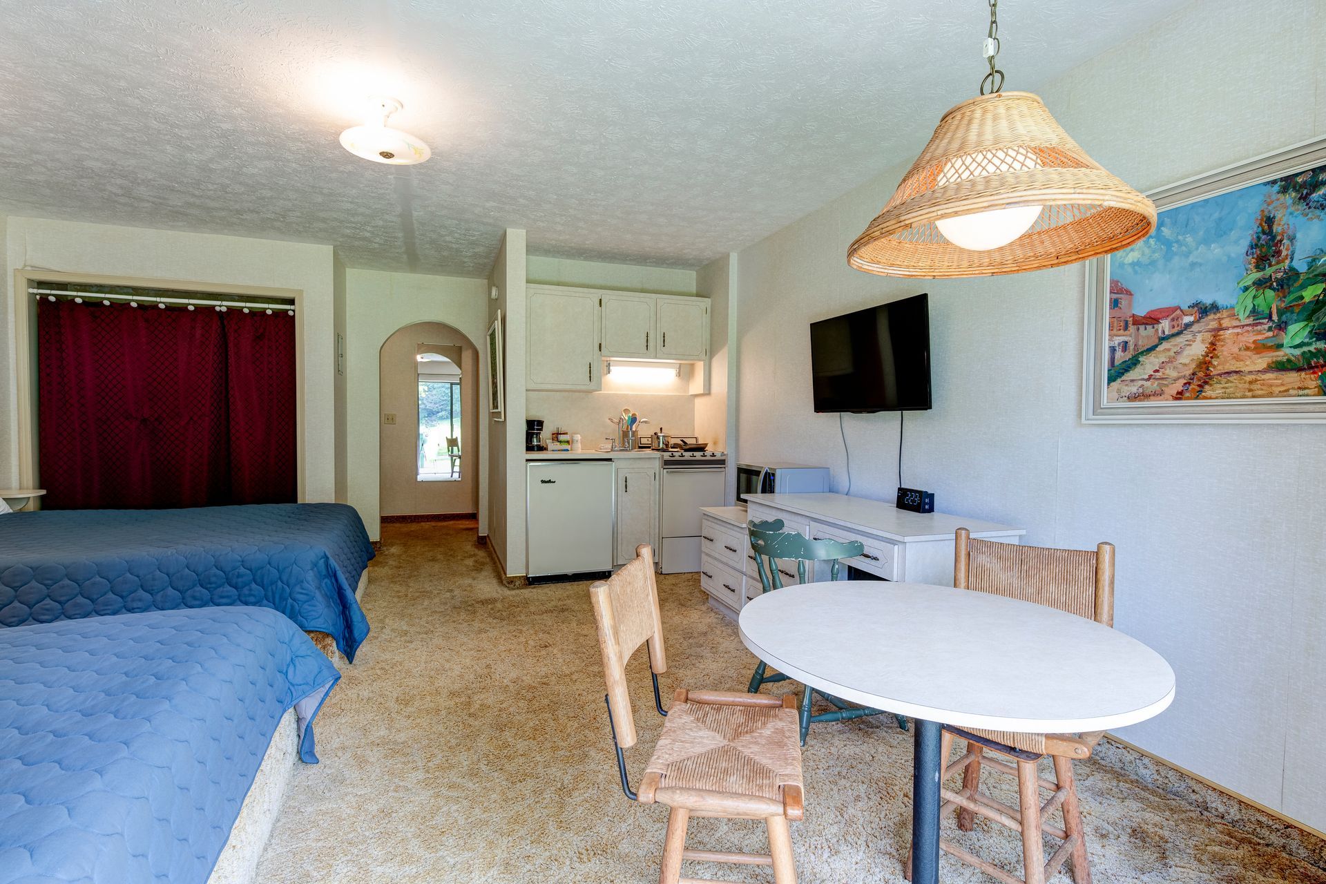 A hotel room with two beds , a table and chairs.