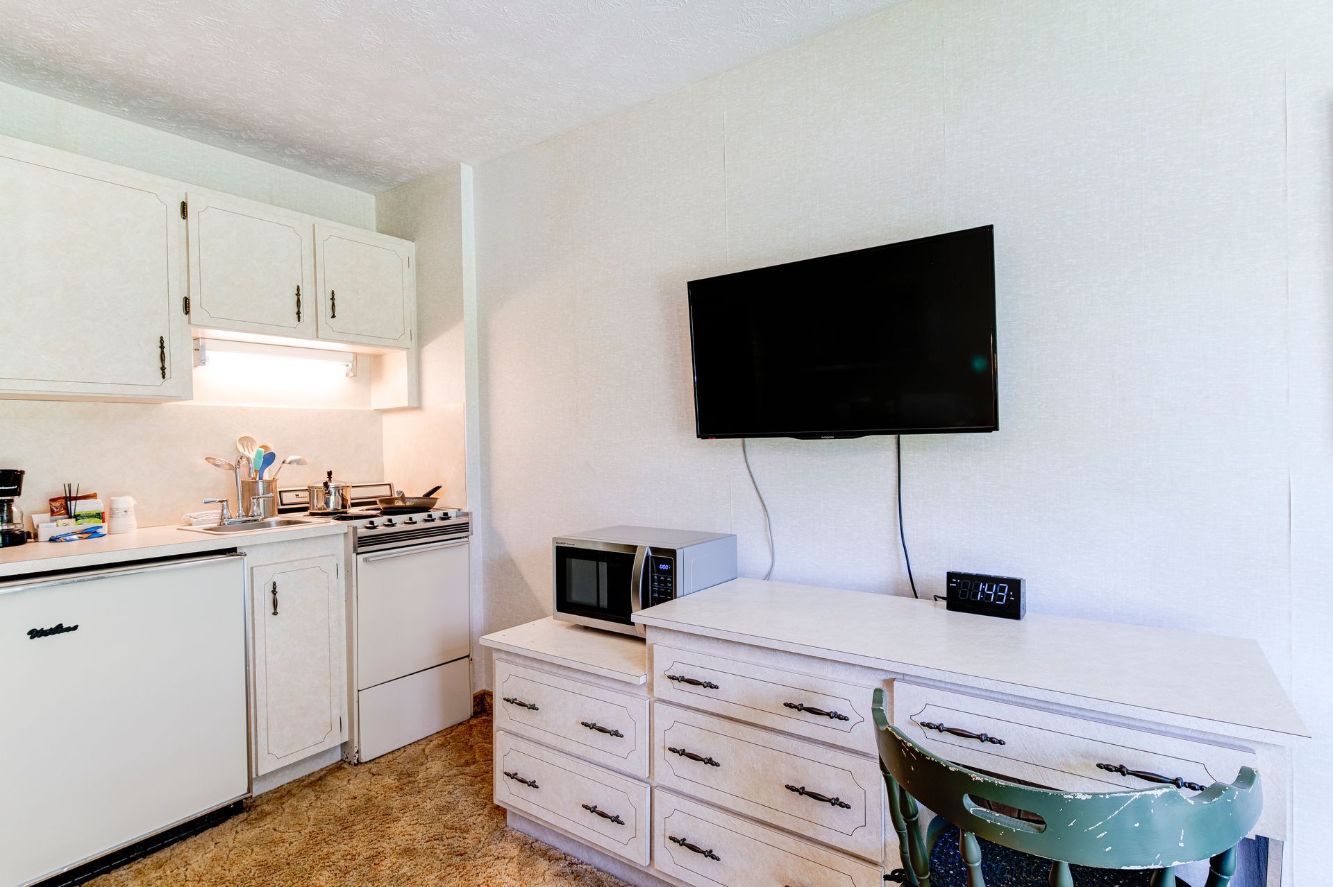 A kitchen with a flat screen tv mounted to the wall.