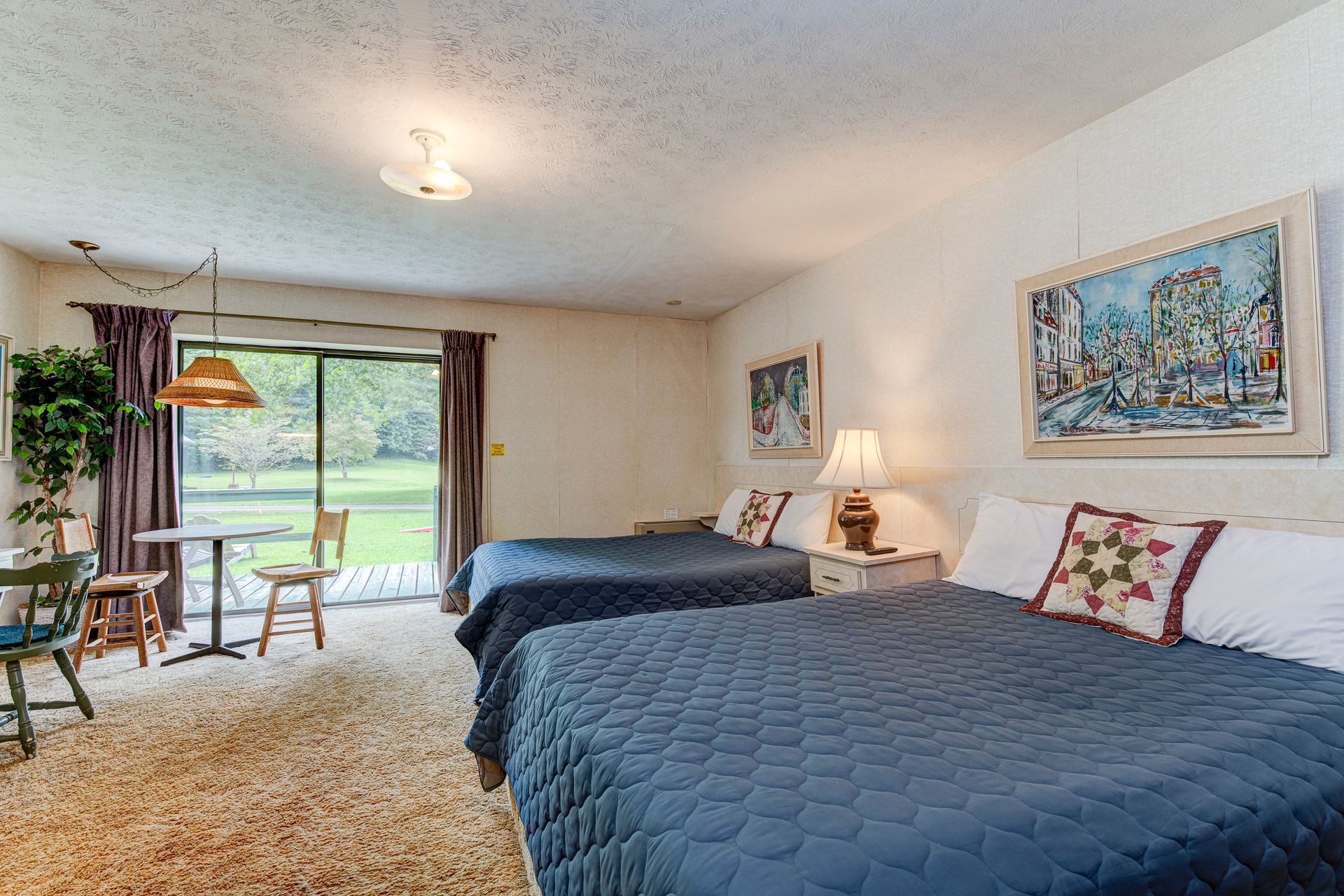 A hotel room with two beds and a table