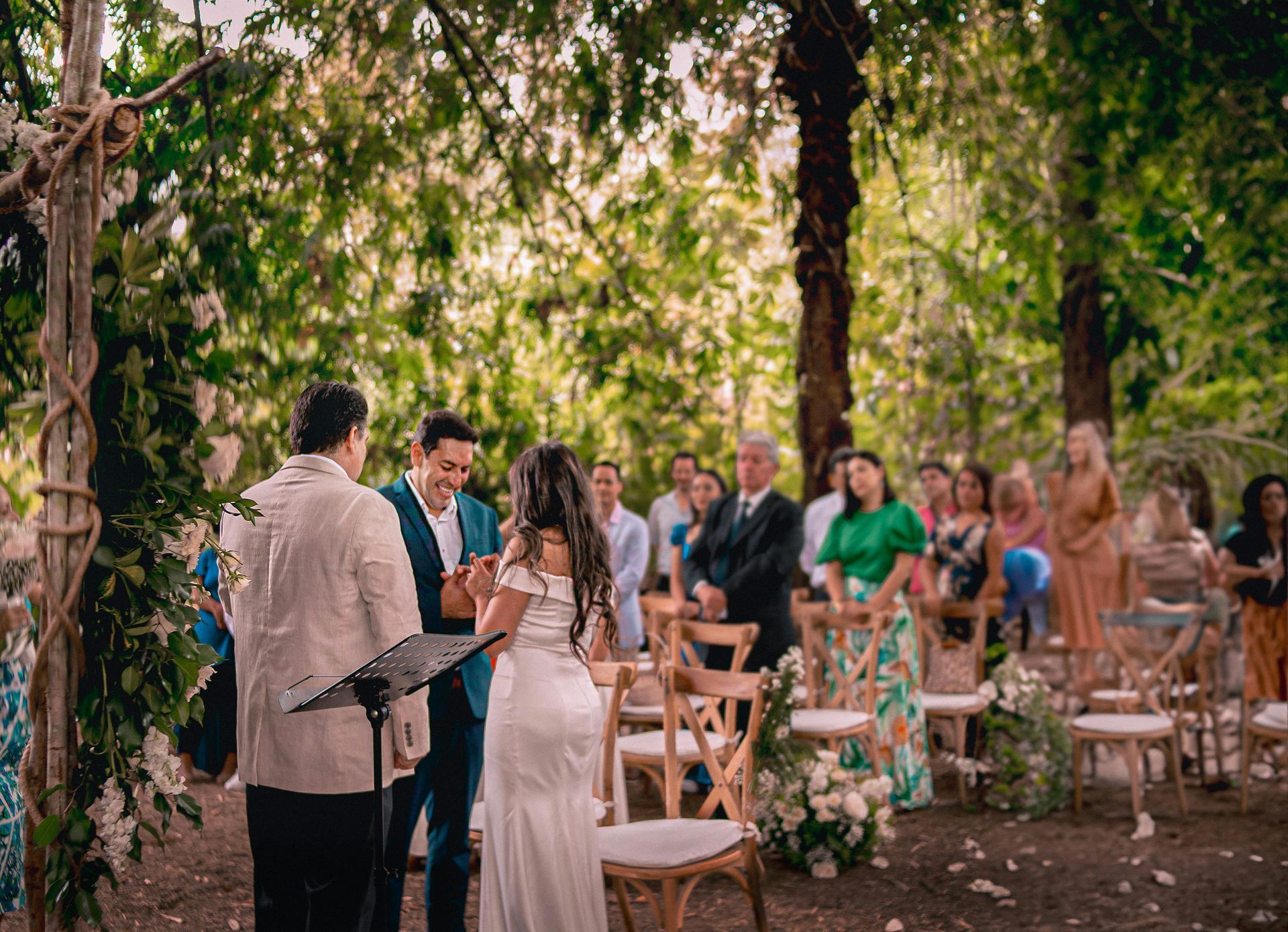 A bride and groom are getting married in a forest.