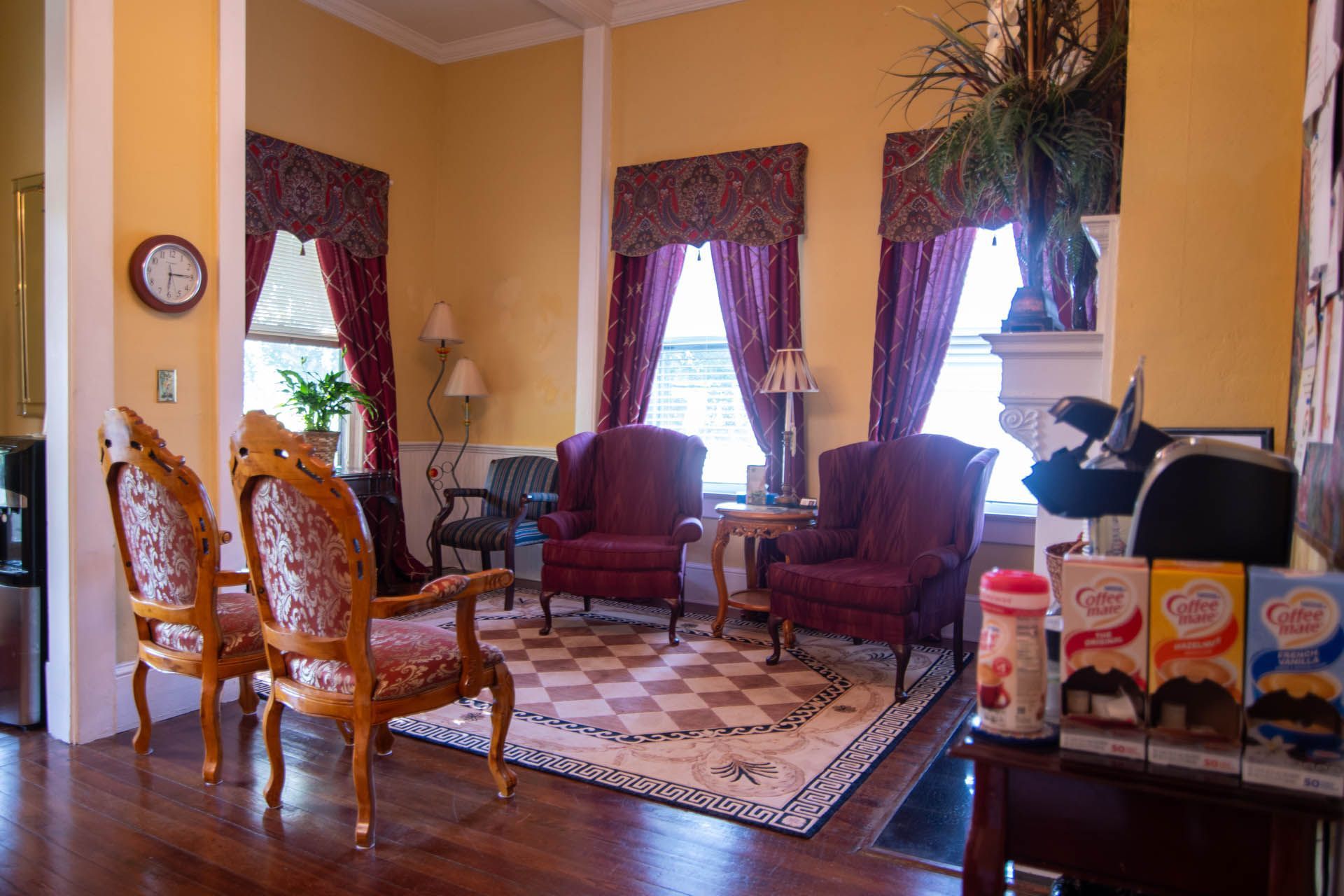 A living room with chairs and a clock on the wall