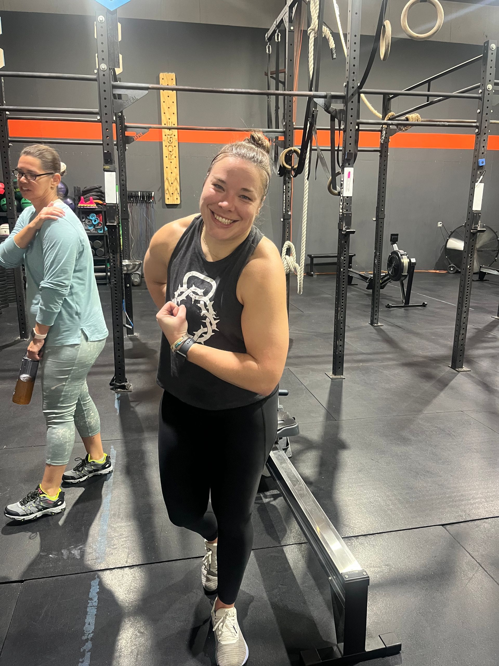 A woman is standing on a balance beam in a gym.
