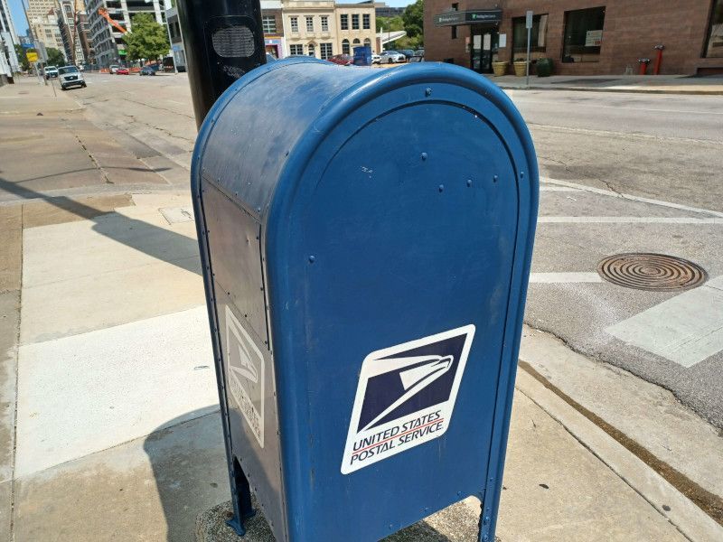 A blue mailbox with the united states postal service logo on it