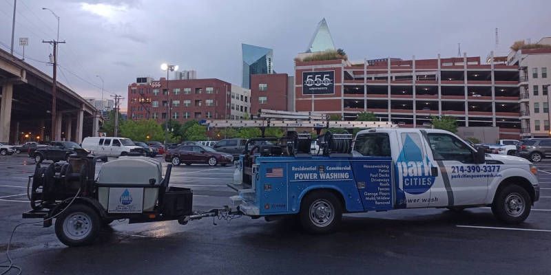 A truck with a trailer attached to it is parked in a parking lot.