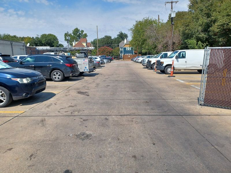 A parking lot filled with cars and trucks on a sunny day.