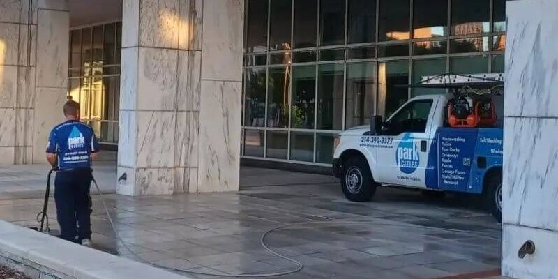 A blue and white van is parked in front of a building