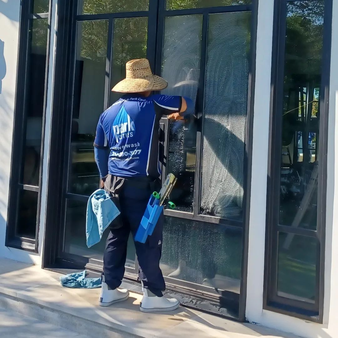 A man in a blue shirt is cleaning a window