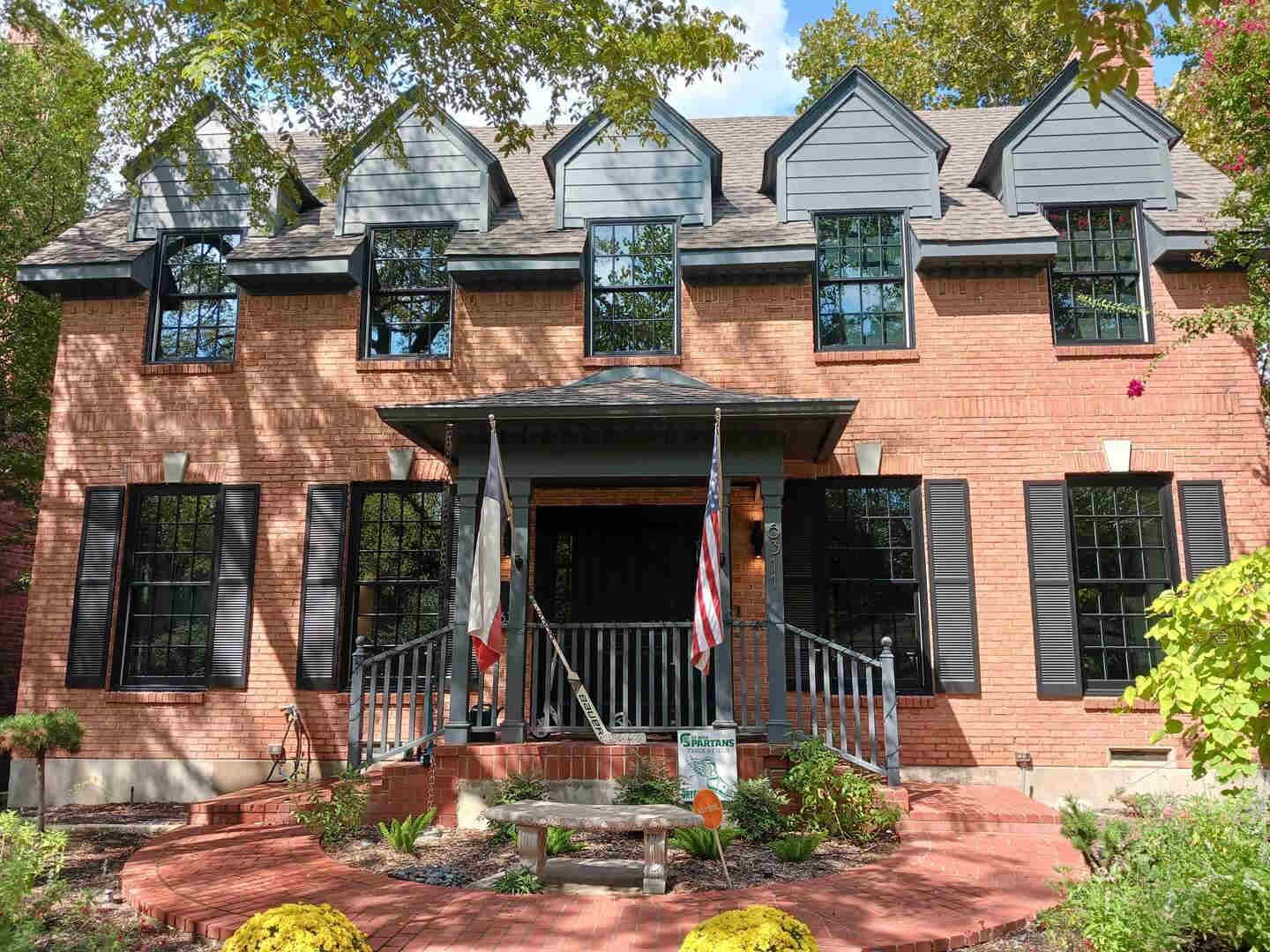 A large brick house with black shutters on the windows