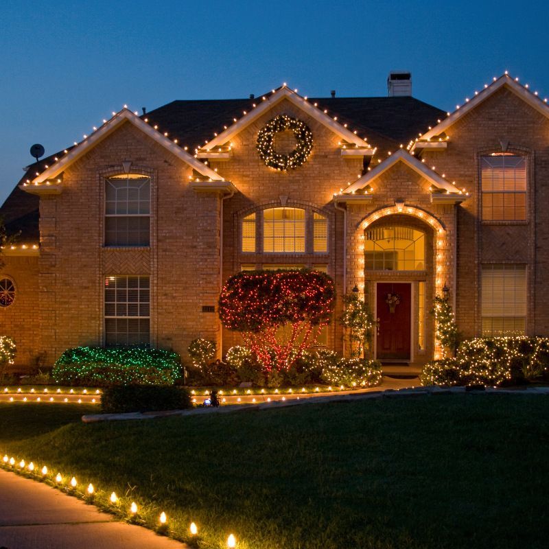 A house is decorated with christmas lights and a wreath