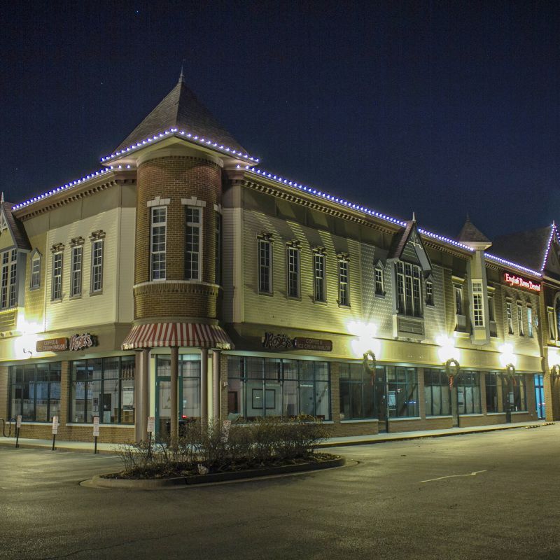 A large building is lit up at night and has a sign that says ' chick-fil-a ' on it