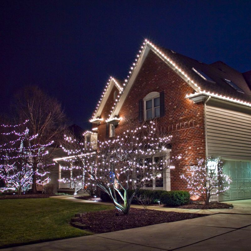 A brick house is decorated with christmas lights at night