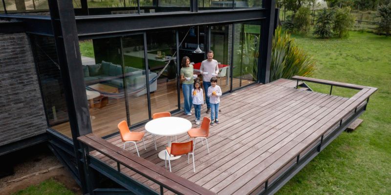 An aerial view of a family standing on a deck in front of a house.