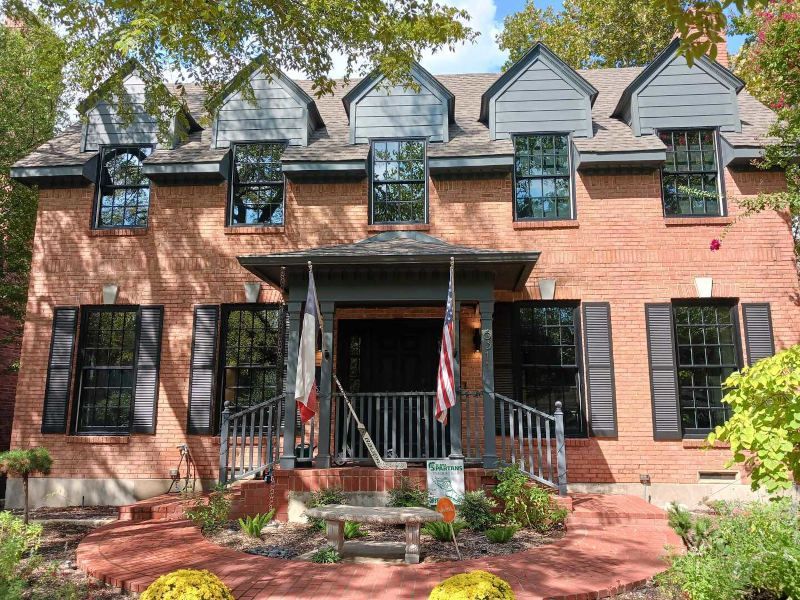 A large brick house with black shutters on the windows