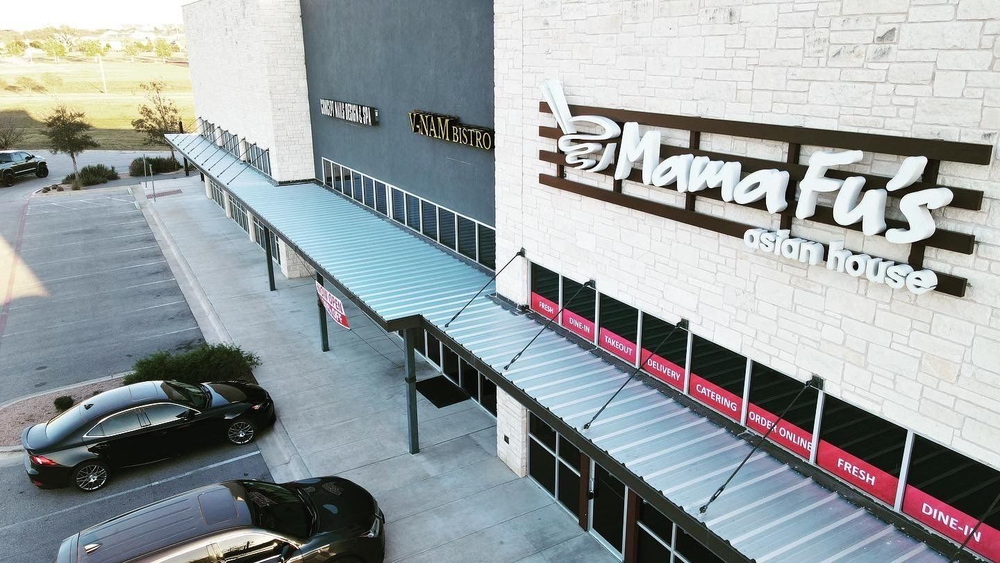 Exterior view of Mama Fu's Asian House restaurant in a commercial building with cars parked nearby.
