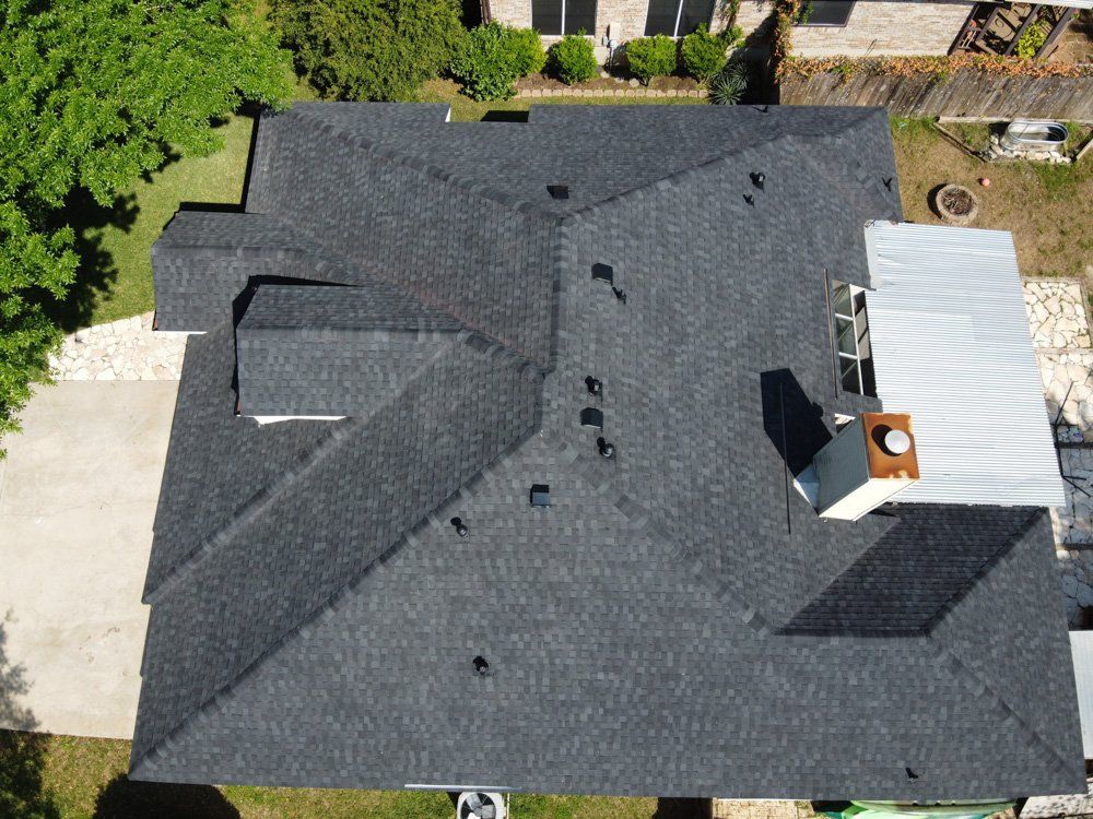 an aerial view of a house with a black roof .