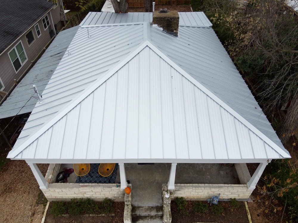 an aerial view of a white house with a metal roof .