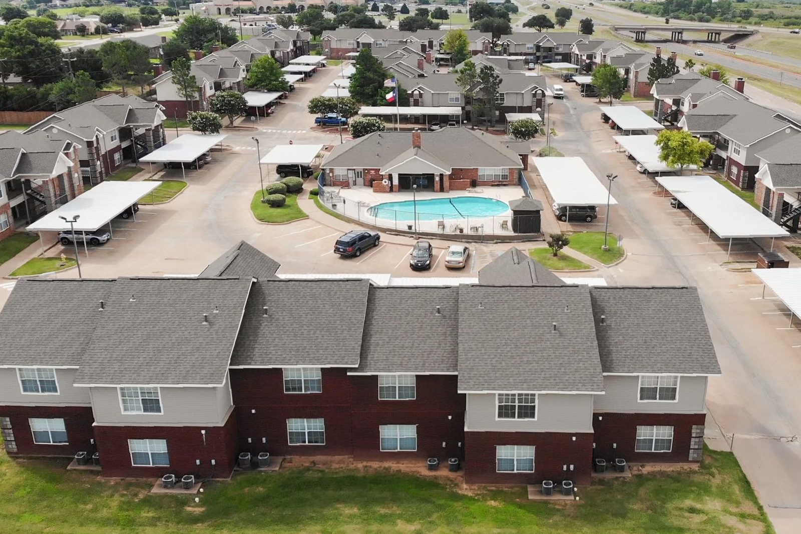 an aerial view of a apartment complex with a pool in the middle