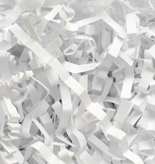 White shredded paper, filling the frame with a textured, chaotic arrangement.