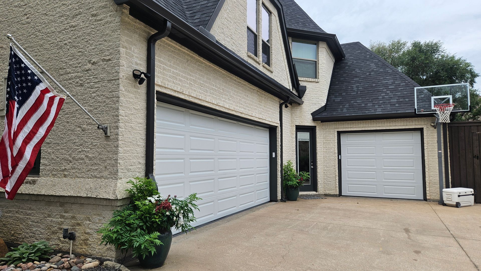House with two garage doors and an American flag.
