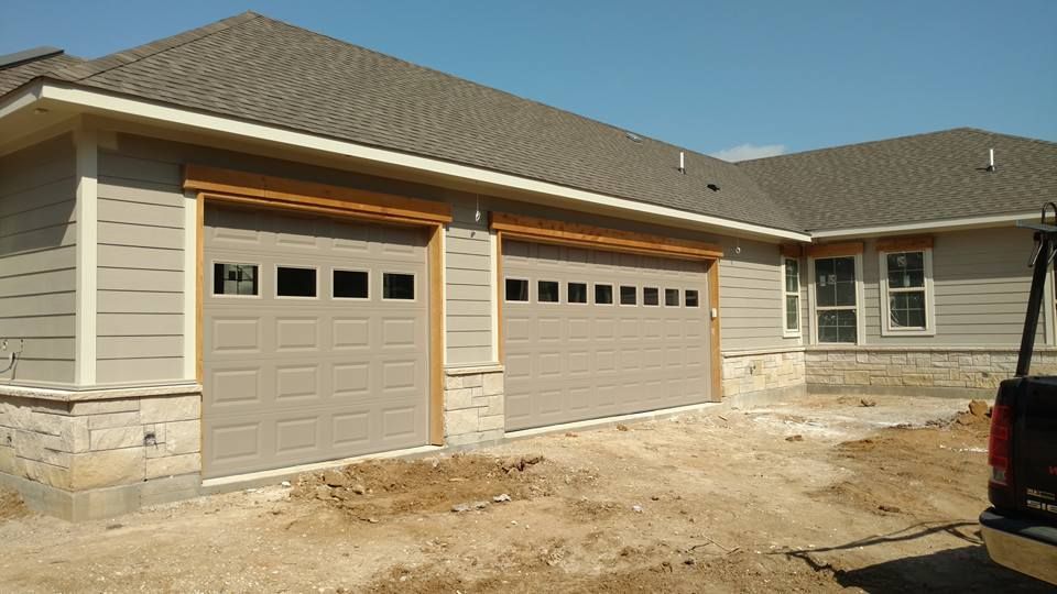 A truck is parked in front of a house with a garage door.